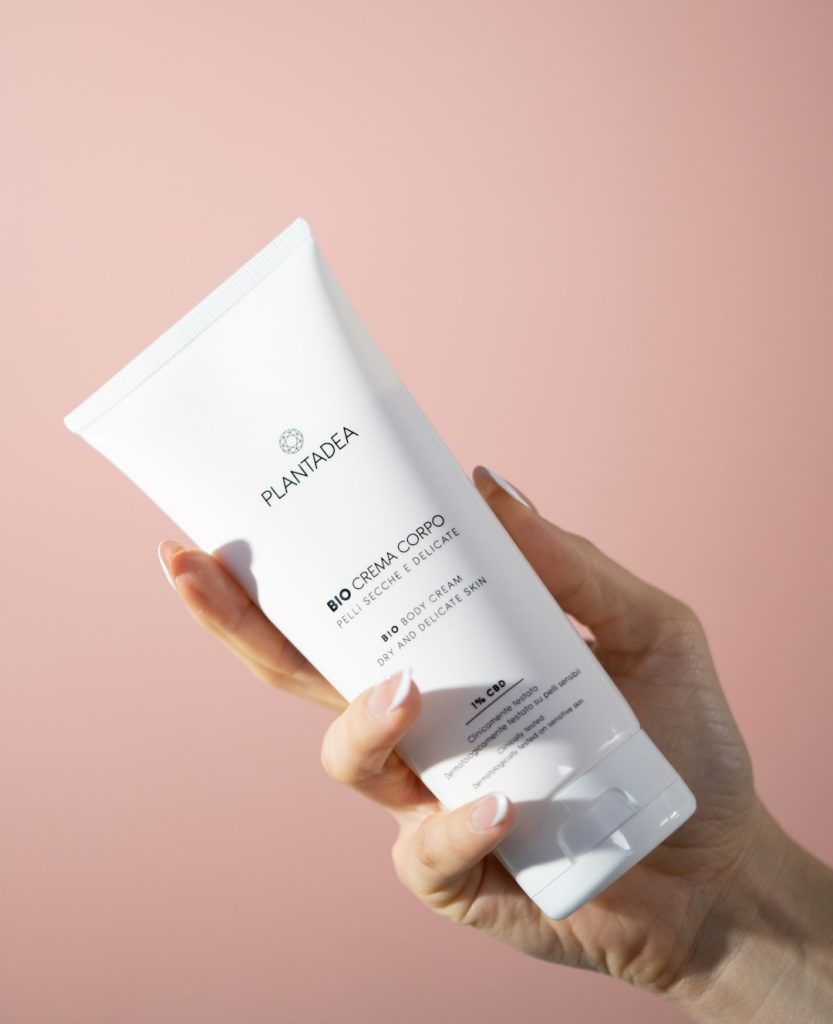 a-person-holding-a-tube-of-white-cream-u-np5almr6u
